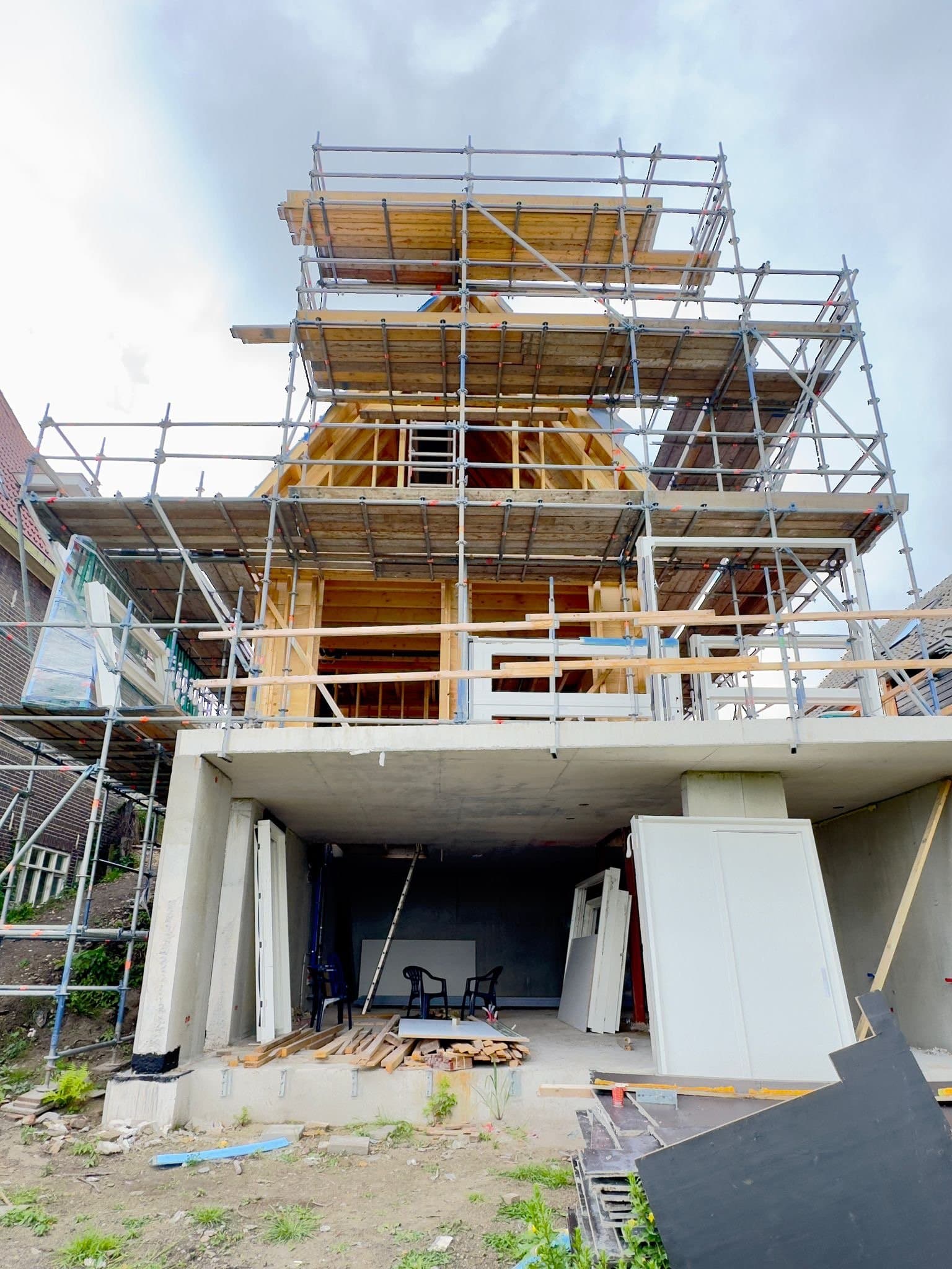 Nieuwe woning aan de dijk: betonnen onderbouw met houtskelet en kap, Amsterdam